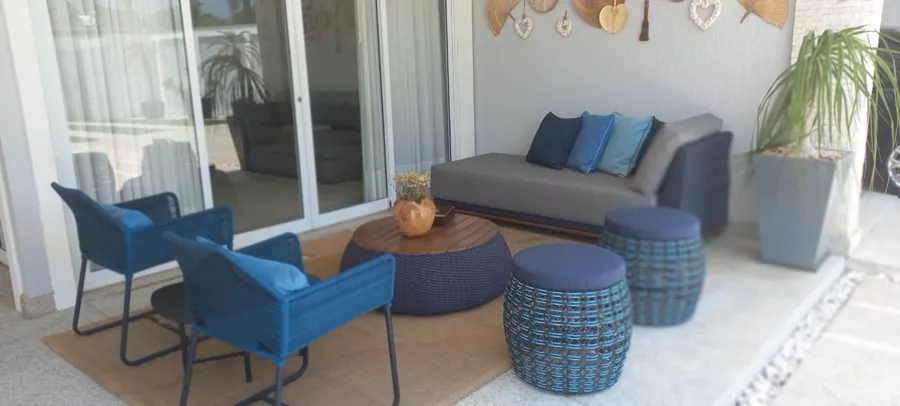 Conjunto de área externa com cadeiras azuis e puffs reformados